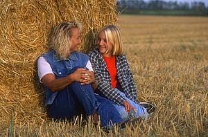Mom and daughter in hayfield