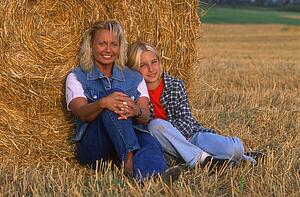 Mom and daughter resting in the hayfield