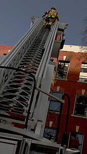 Fireman on ladder near building