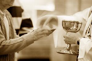 Priest handing over communion wafer