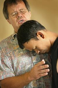 Man praying with teenager