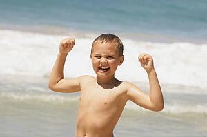 Young boy showing off muscles