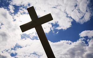 A cross silhouetted against clouds