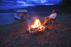 Man on shore relaxing at campfire
