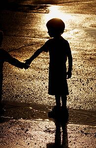 Boy standing in water puddle