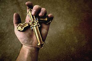 Broken cross in hand
