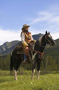 A woman on a horse against mountains