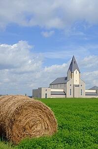 Country church with a hay bale in the foreground