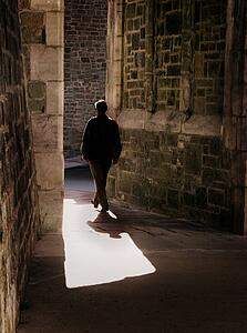 Man walking through old stone buildings