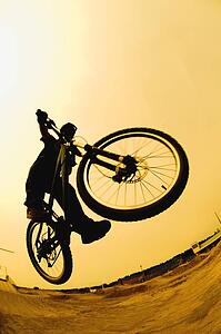 Silhouette of a cyclist against a yellow sky