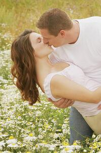Couple kiss in a field of daisies