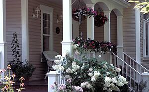A veranda of a house with a garden in the foreground
