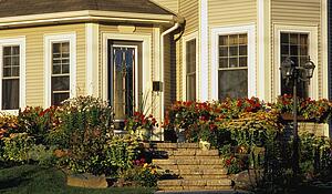 The front entrance of a house with a flower garden