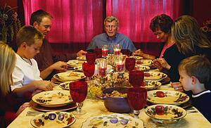 Family praying over Thanksgiving meal