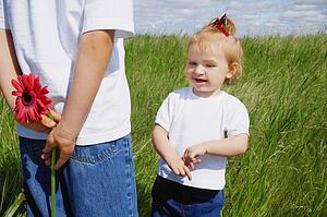 Boy holds a flower behind his back