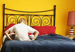 Child sulks on bed