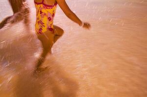 Children run through the water