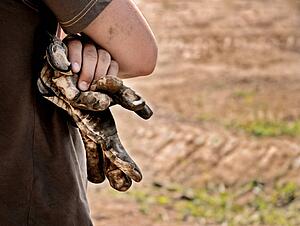 Man with worn gloves in hand