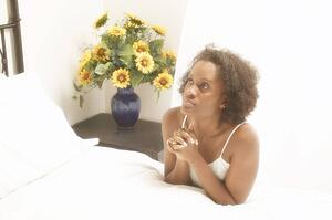 Woman prays by her bedside