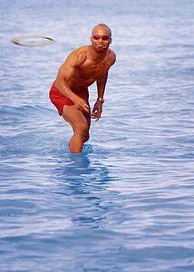 Man playing Frisbee in water