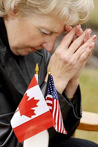 Woman praying over flags from different countries