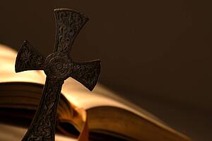 Cross in front of open book