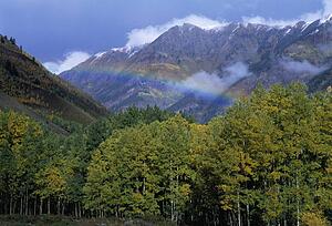 Rainbow and clearing storm in a valley between mountain peaks