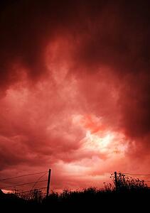Dark sky over open barbed wire fence