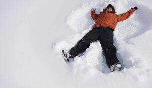 Boy making snow angel