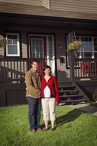 Couple standing in front of new house