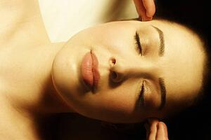 Woman having face massaged