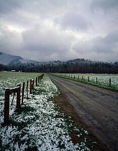 Spring snow on fields and fence row, dirt road, distant mountains in fog, Cades Cove, Great Smoky Mountains National Park