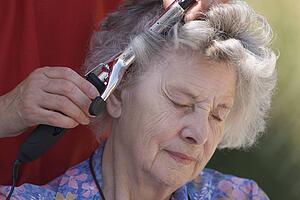 Elderly woman having hair curled