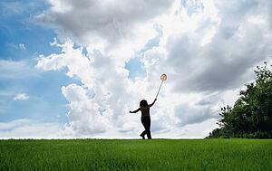 Woman in field with butterfly net