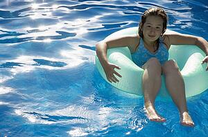 Young girl sitting in tube in water