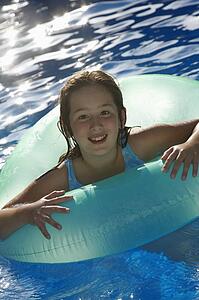 Young girl playing in water inside tube