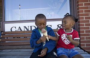 Boy and girl sharing ice cream cone