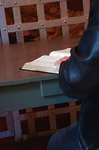Person reading the Bible in prison