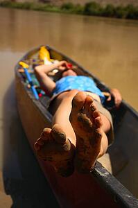 Muddy feet, relaxing in the canoe