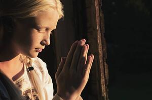 Girl praying in the dark