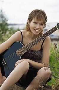 Woman sitting outside with guitar