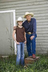 Grandfather and granddaughter wearing cowboy hats