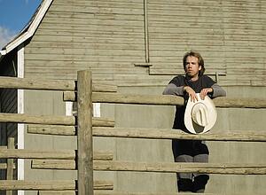 Young man leaning on fence