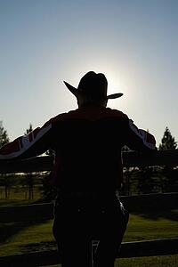 Rancher leaning on a corral