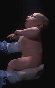 Health professional holding newborn baby