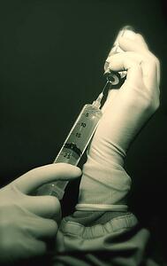 Health professional filling syringe
