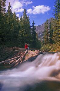 Person drinking coffee beside a waterfall