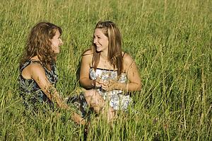 Two young women talking in field