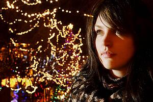 Young woman beside Christmas lights