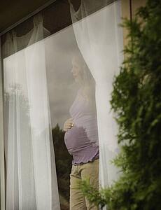 Pregnant woman waiting by the window